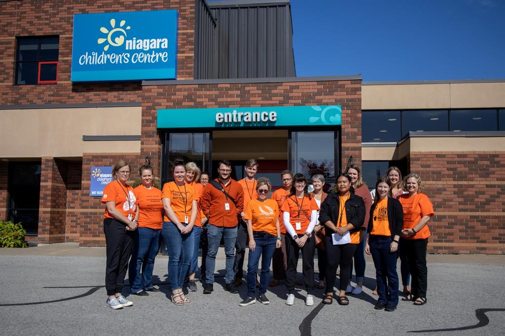 Staff in orange shirts gathered outside